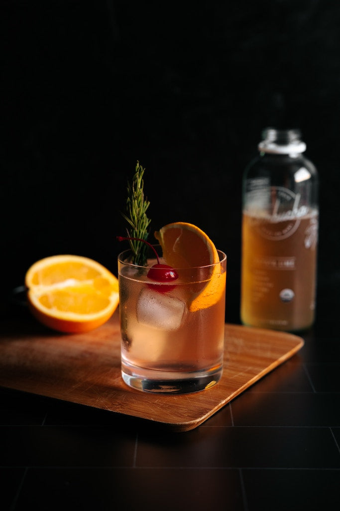 A photo of a beautiful mocktail featuring an orange slice and a cherry.