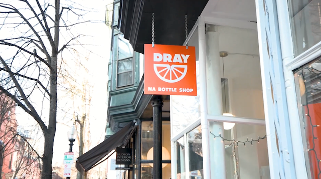 A photo of the orange Dray exterior shop sign with Dray and half-wheel logomark.