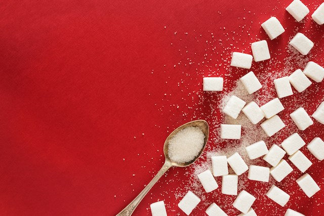 sugar cubes and a spoon on a red background